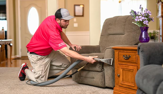 A person cleaning sofa