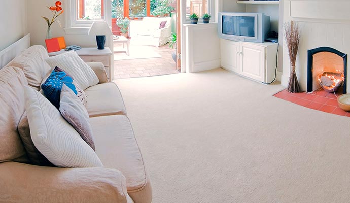 A clean living room with carpeting.