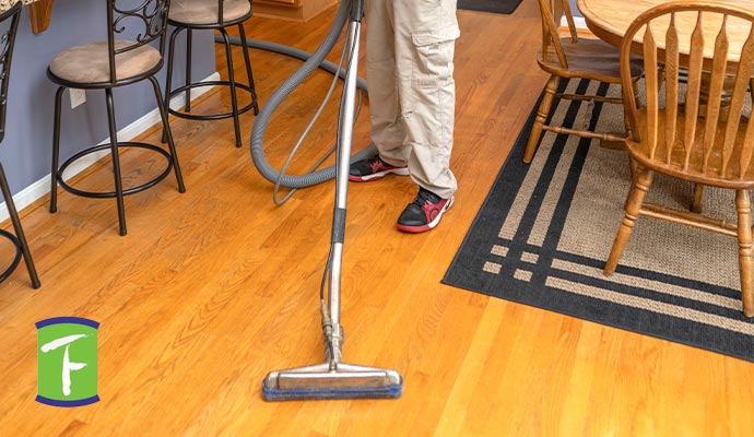 Professional worker cleaning hardwood floor