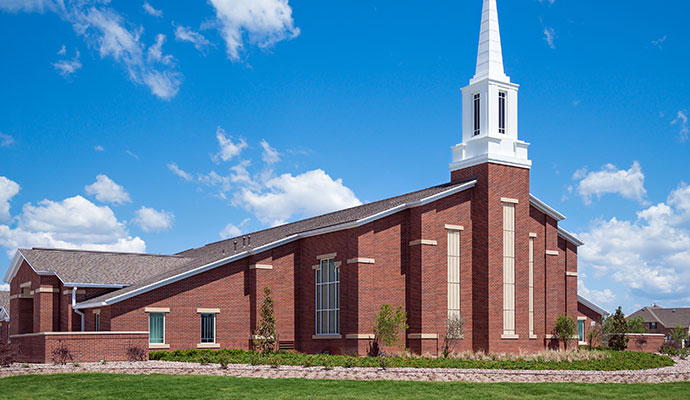 Brick church building exterior with white steeple