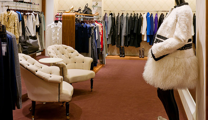 Carpeted seating area with armchairs in retail clothing boutique