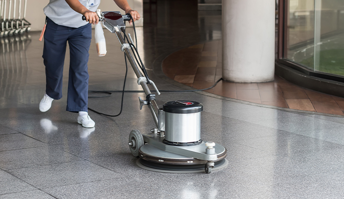 An expert cleaning a floor using a machine in a commercial space