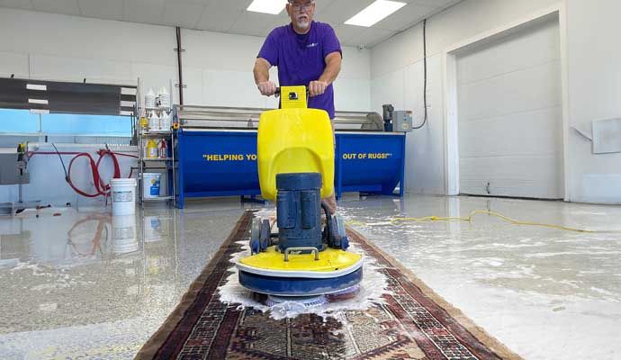 Professional rug cleaning in progress using industrial equipment