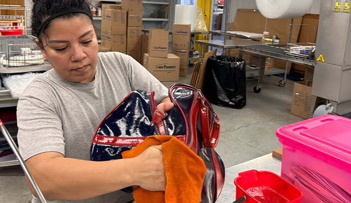 Person cleaning bag with cloth