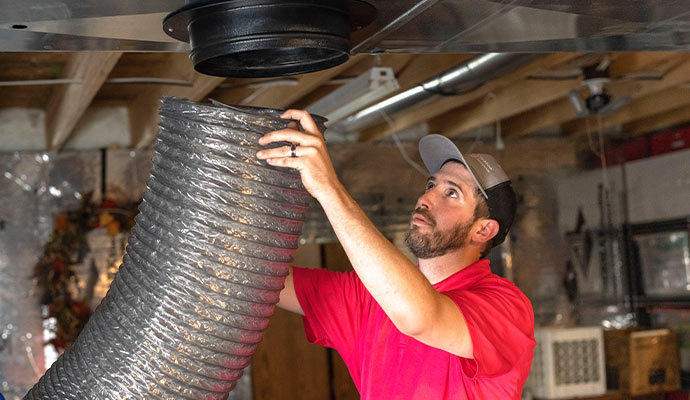 Professional technician cleaning air duct