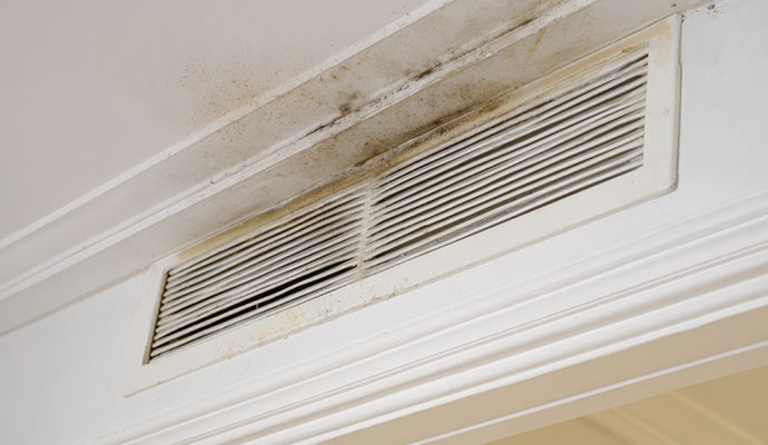 Dirty ceiling air vent with dust buildup