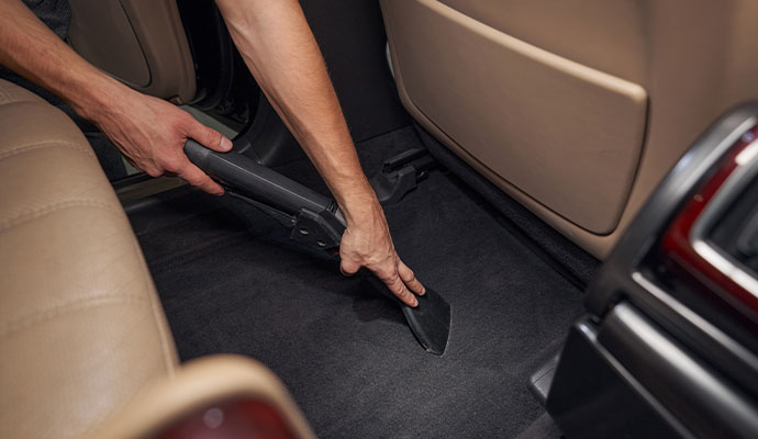 Expert cleaning car carpet with equipment