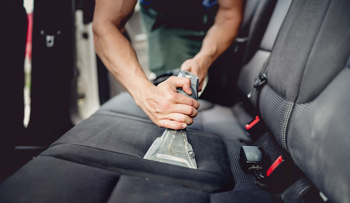 Expert cleaning car seats with equipment