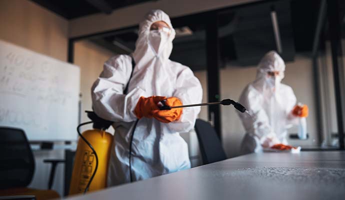 Two experts sanitizing the space